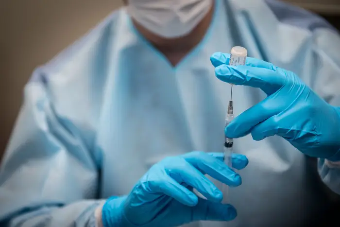 A health care worker prepares a syringe for the coronavirus vaccine at Elmhurst hospital.